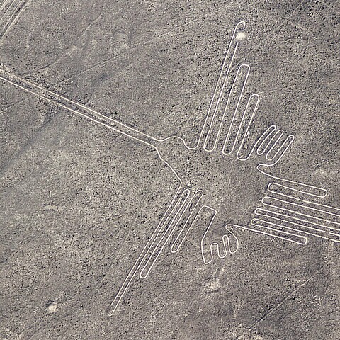 Aerial view of geoglyphs near Nazca - famous Nazca Lines, Peru. In the center, a hummingbird figure is present.
