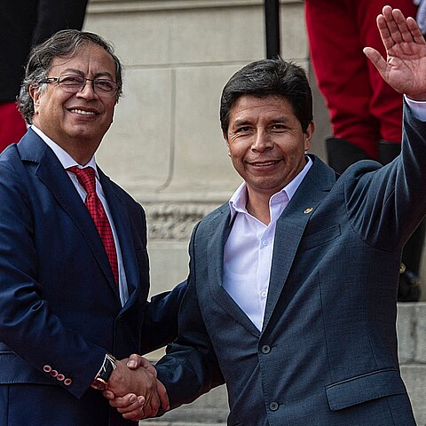 El presidente de Colombia Gustavo Petro (L) y el expresidente peruano Pedro Castillo (R) dan la mano