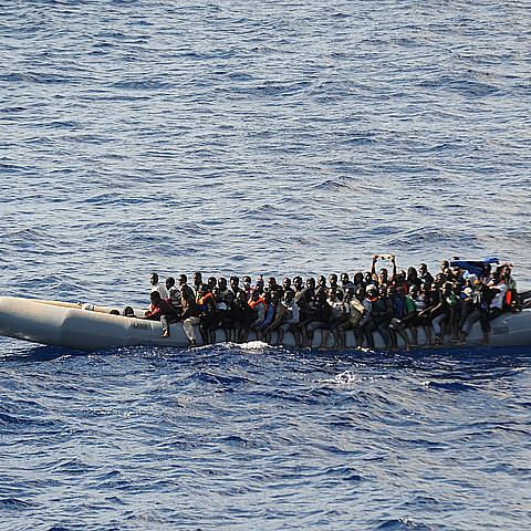 Una pequeña embarcación de goma llena de inmigrantes