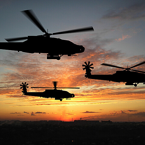 U.S. Army Blackhawk helicopters fly over Iraq at sunset