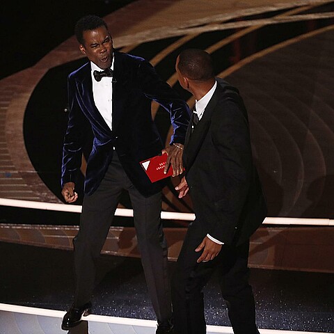 Actor Will Smith (d) mientras abofetea al presentador de la gala Chris Rock (i) durante la 94ª ceremonia anual de los Premios de la Academia de Cine 