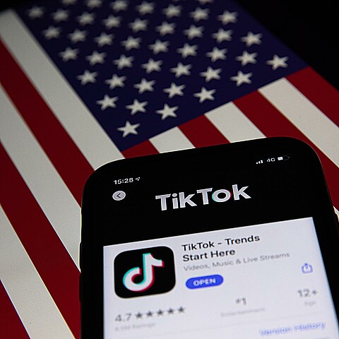 Aplicación de TikTok sobre imagen de bandera de EE. UU. 