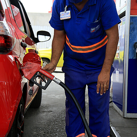 Empleado de gasolinera durante el repostaje de un vehículo