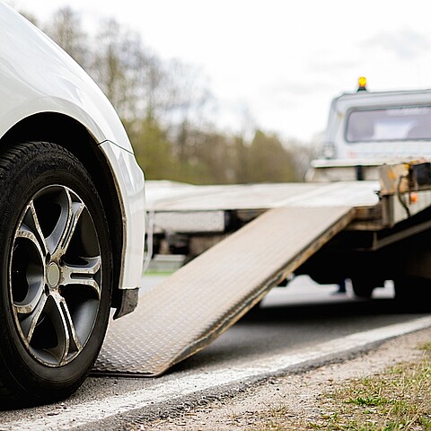 Cargando un vehículo en una grúa al borde de una carretera