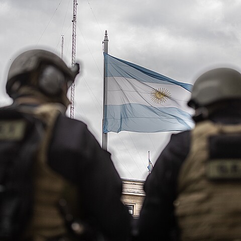 bandera nacional argentina se ve a través de dos oficiales de las fuerzas tácticas