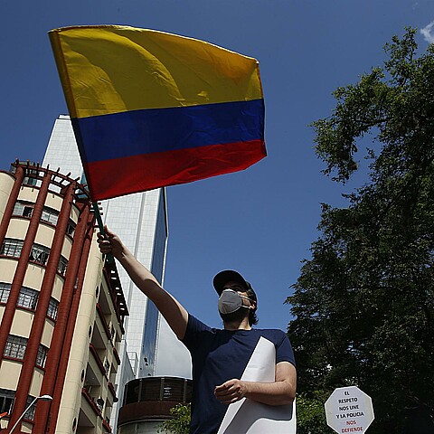Hombre sostiene una bandera de Colombia