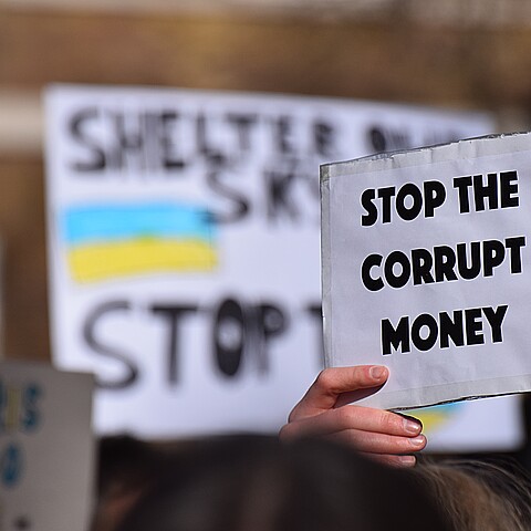 A protest sign that reads ‘Stop the Corrupt Money’ being held by a demonstrator outside Downing Street supporting more sanctions to help Ukraine