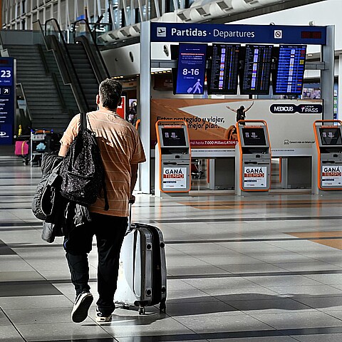 Un joven camina con su maleta en el Aeropuerto Internacional Ezeiza en Buenos Aires (Argentina).