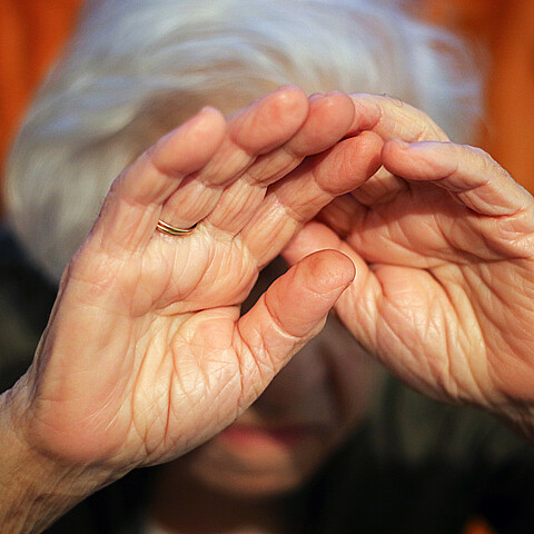 Anciana tapándose la cara