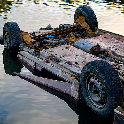 Un vehículo oxidado vertido en el agua de un estanque