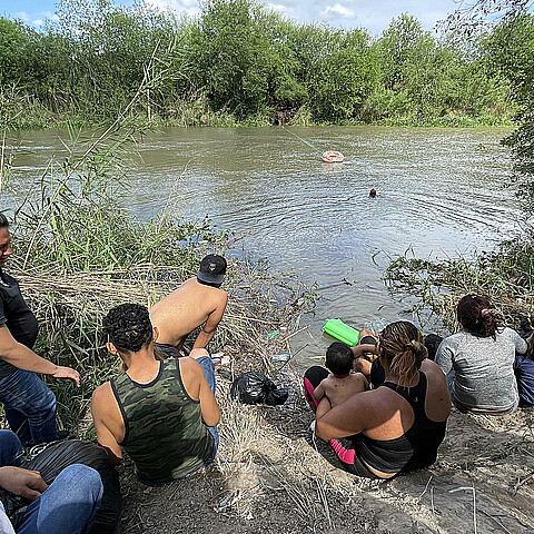 Un grupo de migrantes, ayudados de un inflable, intentan cruzar el Río Bravo el 11 de abril de 2023, en la ciudad de Matamoros en Tamaulipas