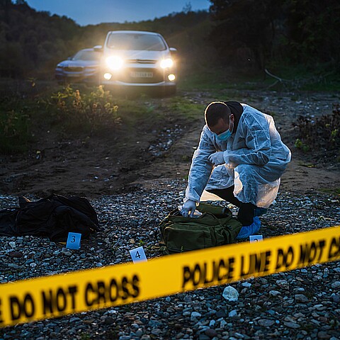 Investigador de la policía forense reuniendo pruebas en la escena del crimen