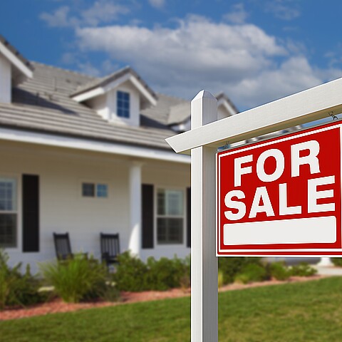 Firma inmobiliaria en venta frente a casa nueva.