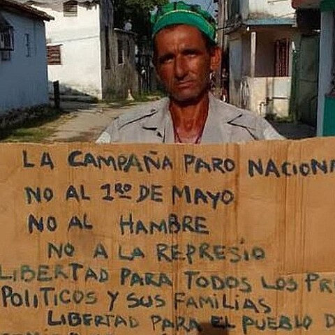 Trabajador cubano se manifiesta pacíficamente con un cartel en contra del régimen 