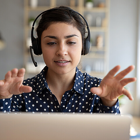 Joven mujer en una videoconferencia con auriculares
