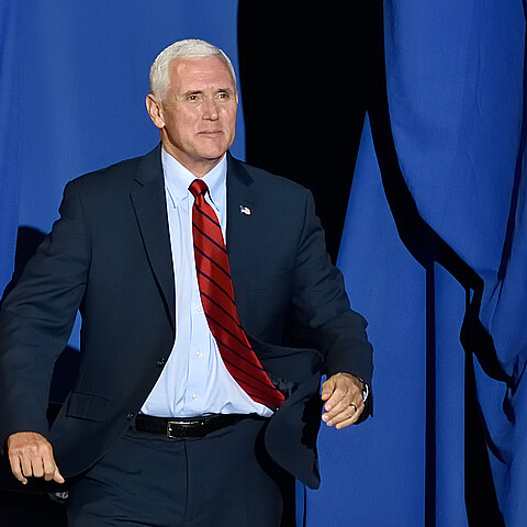 Vice President Mike Pence "bursts" through the opening on stage at a rally in 2017