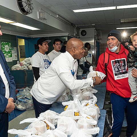 Mayor Eric Adams helps distribute donated food and clothing to families of asylum seekers housed in the city at public school 20 in New York, Feb. 11, 2023