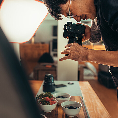 Un fotógrafo varón dispara comida sobre la mesa