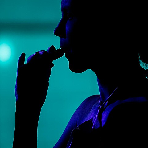Joven inhalando vapor de un cigarillo electrónico