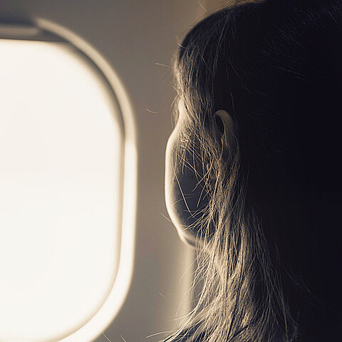 Mujer viendo por la ventana de un avión