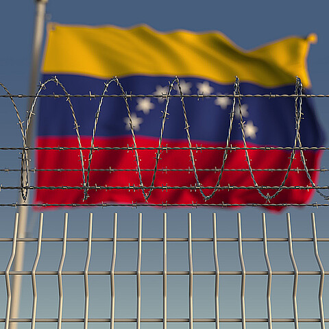 Image of Venezuelan flag above barbed wire