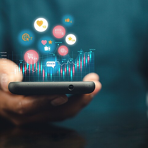 Smartphone sujetado con una mano con iconos de aplicaciones