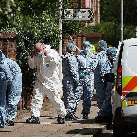 Oficiales forenses trabajan en la escena de un incidente que involucró a un hombre con una espada