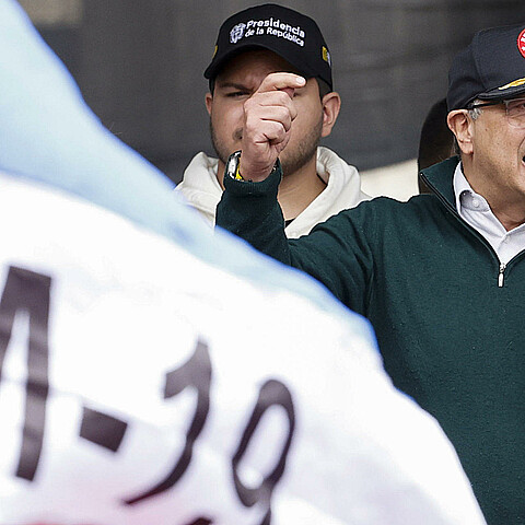 El presidente colombiano Gustavo Petro y una bandera del grupo guerrillero M-19