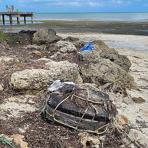 Fotografía de una bolsa plástica atada con cuerdas con los ladrillos de droga en el interior que fue hallada por un bañista este miércoles, en una playa sin especificar de los Cayos de Florida (EE. UU). 