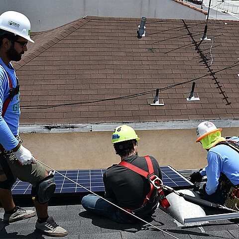 Trabajadores instalando paneles solares en una vivienda