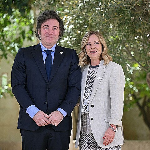 La primera ministra italiana, Giorgia Meloni (d), recibe al presidente argentino, Javier Milei (i), durante la segunda jornada de la cumbre del G7