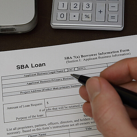 Una persona llenando el formulario de solicitud de crédito para pequeña empresa de la SBA