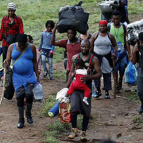 Fotografía de archivo fechada el 28 de septiembre de 2021 que muestra a migrantes haitianos en su camino hacia Panamá por el Tapón del Darién en Acandi (Colombia)