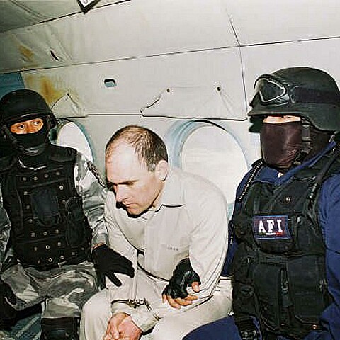 Dos policías escoltan a Osiel Cárdenas (centro), un capo del narcotráfico que el Gobierno de México extraditó a Estados Unidos en 2007