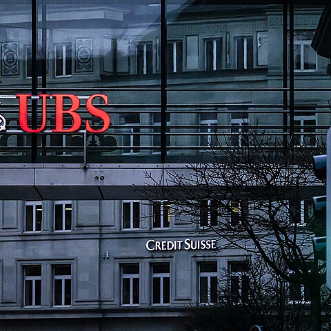  Los logotipos de los bancos suizos Credit Suisse y UBS aparecen en distintos edificios detrás de los semáforos de Zúrich