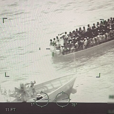 Fotografía del 17 de agosto 2024 cedida por la Guardia Costera de los Estados Unidos de una imagen de control donde aparece parte de la tripulación del buque guardacostas Paul Clark (i) interceptando una expedición de migrantes adosados en una embarcación a 91 kms (57 millas) al sur de las Islas Turcas y Caicos