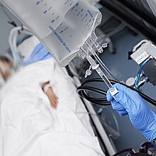 Una persona apaga el sistema de drogas intravenosas al paciente inconsciente.