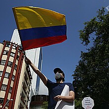 Hombre sostiene una bandera de Colombia