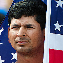 Hispanic man embracing American flag