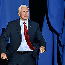Vice President Mike Pence "bursts" through the opening on stage at a rally in 2017