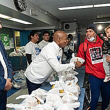 Mayor Eric Adams helps distribute donated food and clothing to families of asylum seekers housed in the city at public school 20 in New York, Feb. 11, 2023