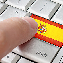 A computer keyboard in English features a Spanish flag