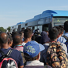 Migrants waiting to board bus