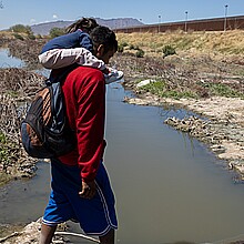 Migrants crossing river