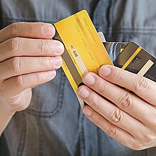 Hombre con varias tarjetas de crédito y está eligiendo una tarjeta de crédito para pagar