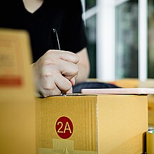 Hombre llenando formulario sobre una caja