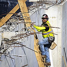Hombre en una escalera en una obra de construcción