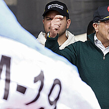 El presidente colombiano Gustavo Petro y una bandera del grupo guerrillero M-19