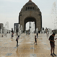 Personas juegan en una fuente del Monumento a la Revolución, en la Ciudad de México. 