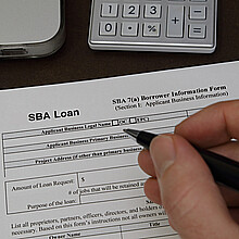 Una persona llenando el formulario de solicitud de crédito para pequeña empresa de la SBA